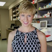 Woman with a blonde pixie haircut in a pharmacy